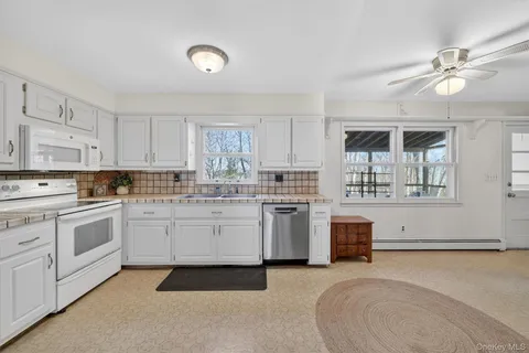 a kitchen with white cabinets and sink