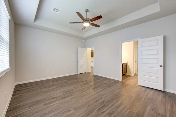 a view of an empty room with wooden floor
