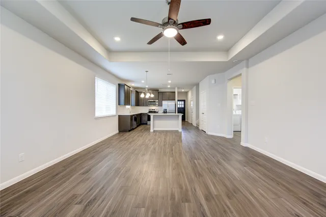 a view of kitchen with kitchen island wooden floors appliances and cabinets