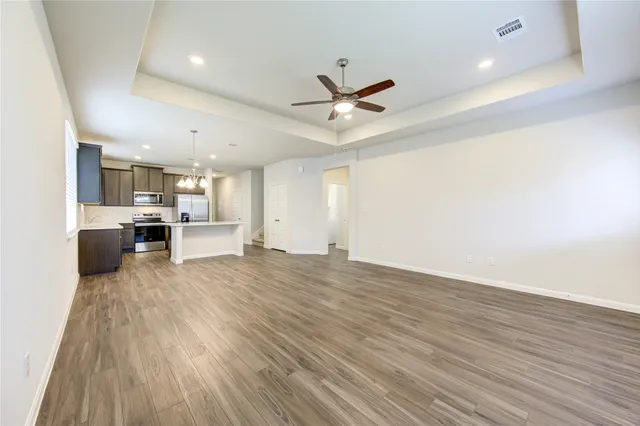 a view of a kitchen with a wooden floor and a ceiling fan