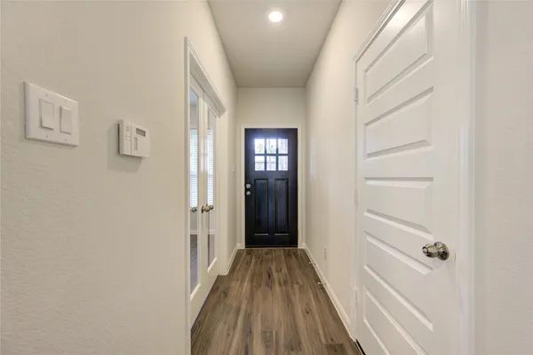 a view of a hallway with wooden floor and closet