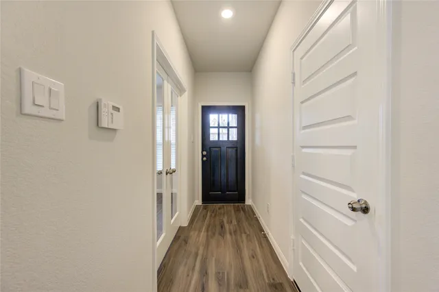 a view of a hallway with wooden floor and closet