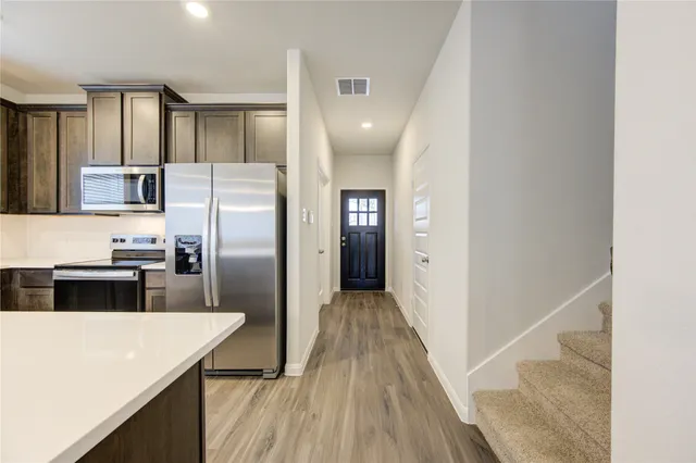 a kitchen with stainless steel appliances a refrigerator and a stove top oven