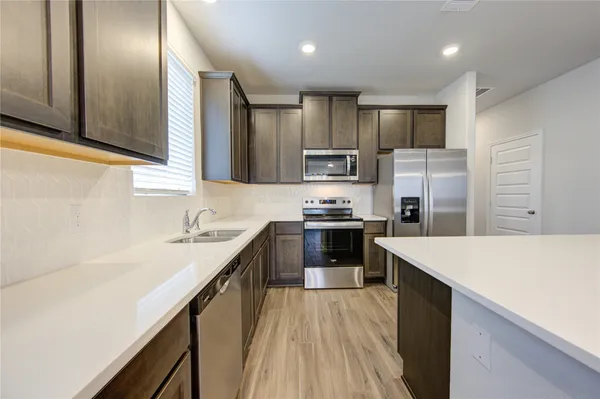 a kitchen with kitchen island a sink stove and refrigerator
