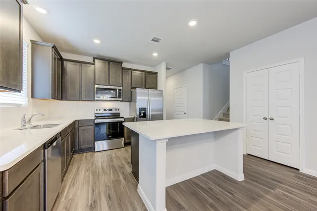 a kitchen with kitchen island a sink stove and refrigerator