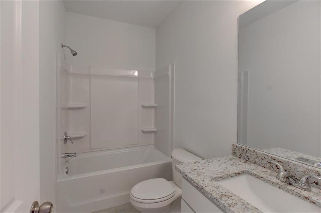 41 Woodland Road Covington, GA 30016 - Photo 19 of 35 a bathroom with a granite countertop bathtub toilet sink vanity and shower