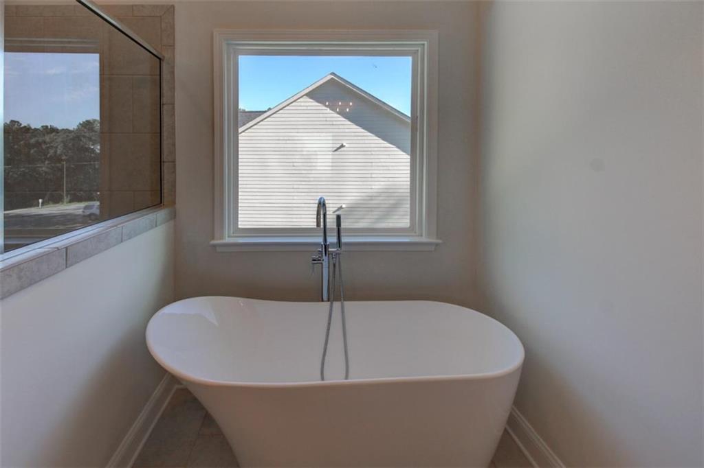 41 Woodland Road Covington, GA 30016 - Photo 27 of 35 a white bath tub sitting in a bathroom