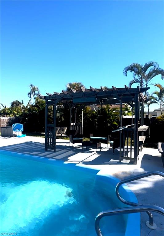 Outdoor pool with a pergola and a patio area