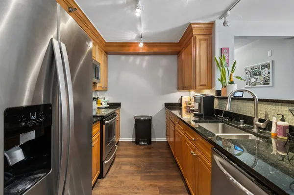 a kitchen with stainless steel appliances granite countertop a sink and a stove
