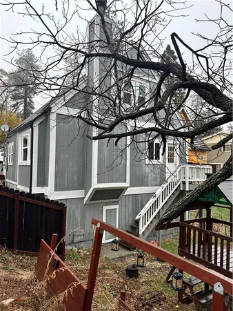 a view of a house with a small yard and wooden fence