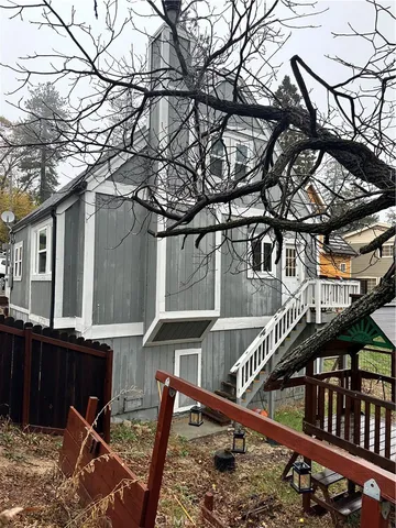 a view of a house with a small yard and wooden fence