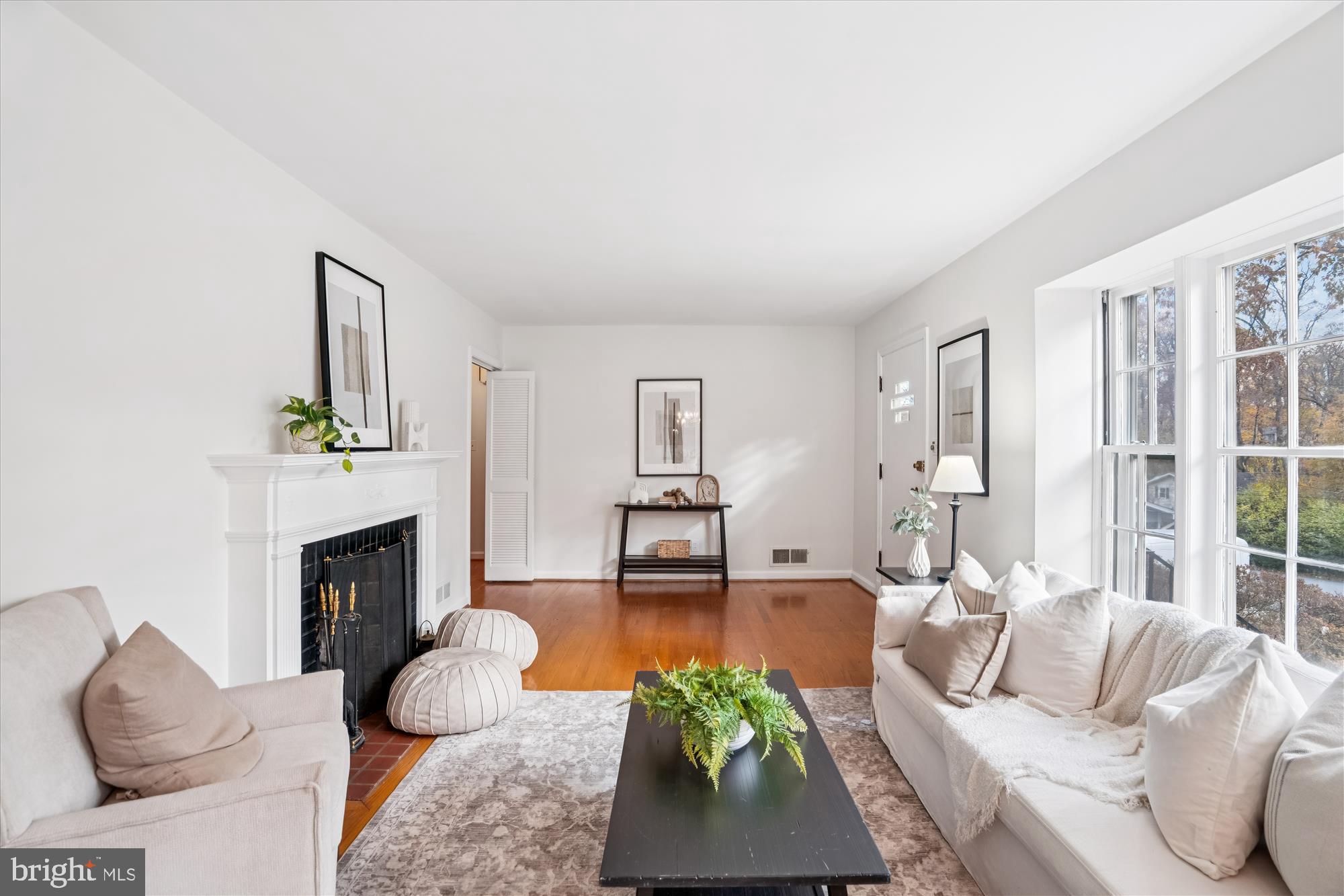 a living room with furniture a fireplace and a large window