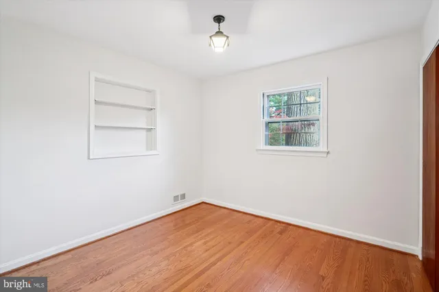 an empty room with wooden floor and closet