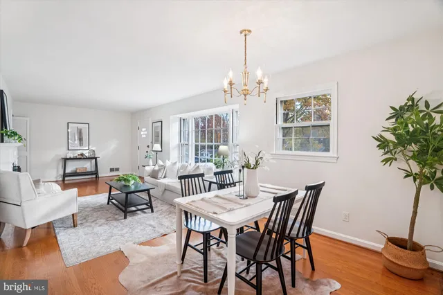 a view of a livingroom and dining room with furniture wooden floor a chandelier