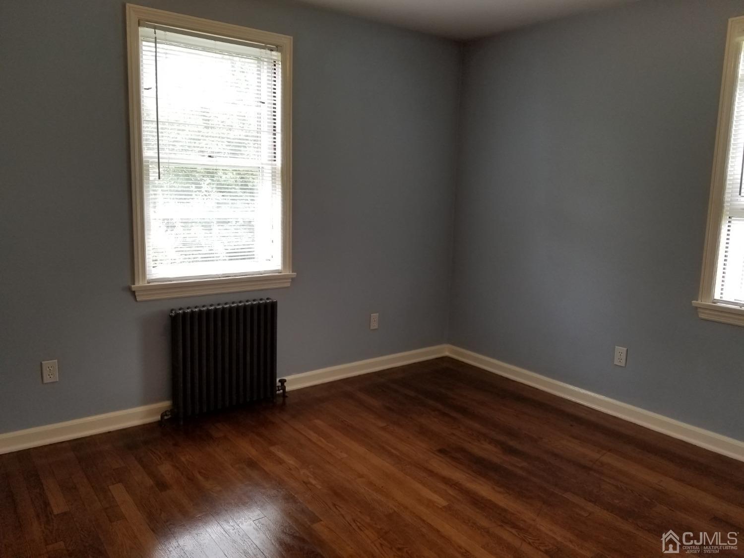 672 Hermann Road North Brunswick, NJ 08902 - Photo 3 of 15 an empty room with wooden floor and windows