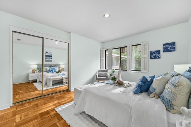 a bedroom with a bed and large windows