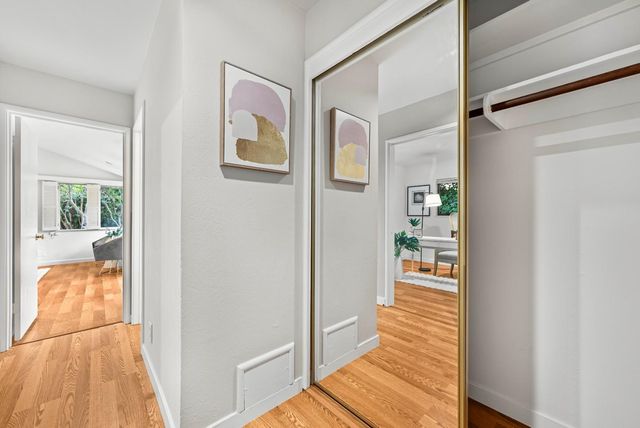 a view of a hallway with wooden floor and a living room