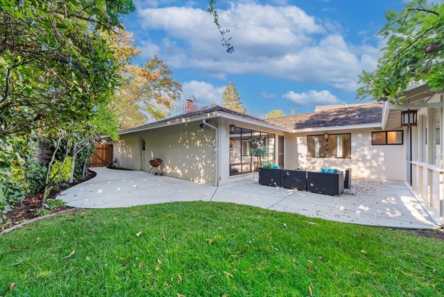 a view of a house with a yard and sitting area