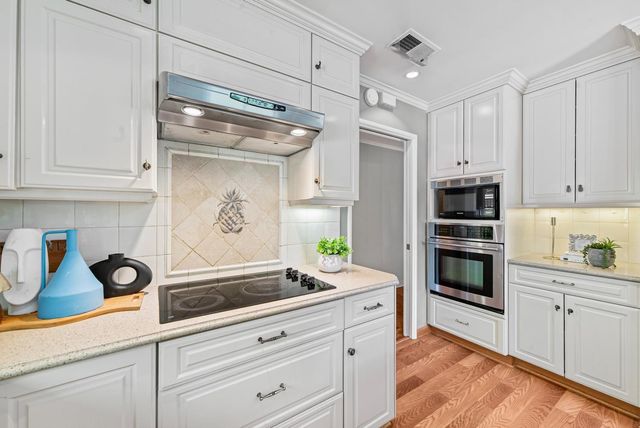 a kitchen with granite countertop a sink stainless steel appliances and cabinets