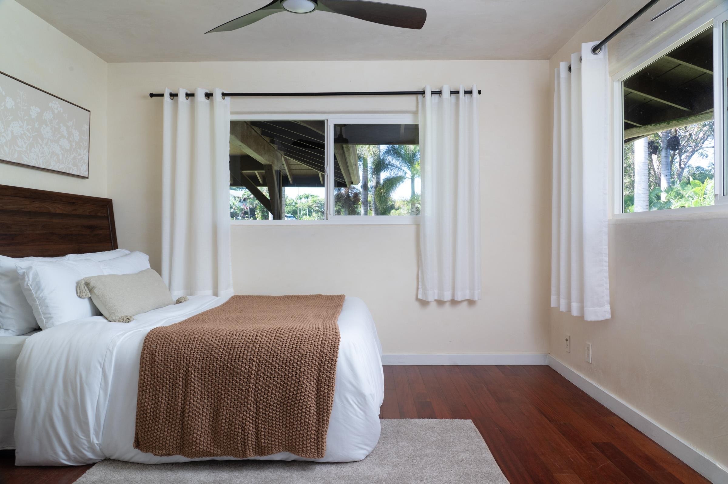 4509 Opana Place Haiku, HI 96708 - Photo 16 of 31 a bedroom with a bed wooden floor and window