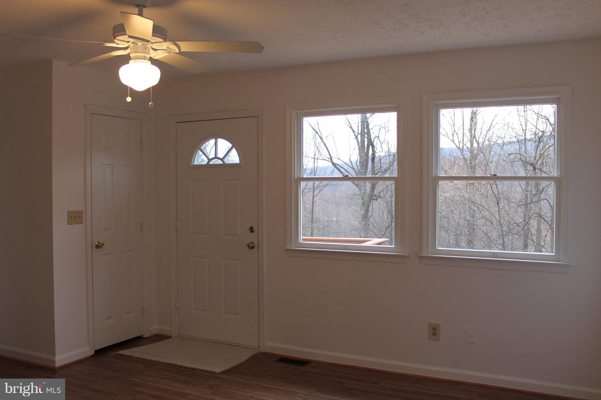 44 Hickory Tree Road Front Royal, VA 22630 - Photo 8 of 30 an empty room with wooden floor fan and windows