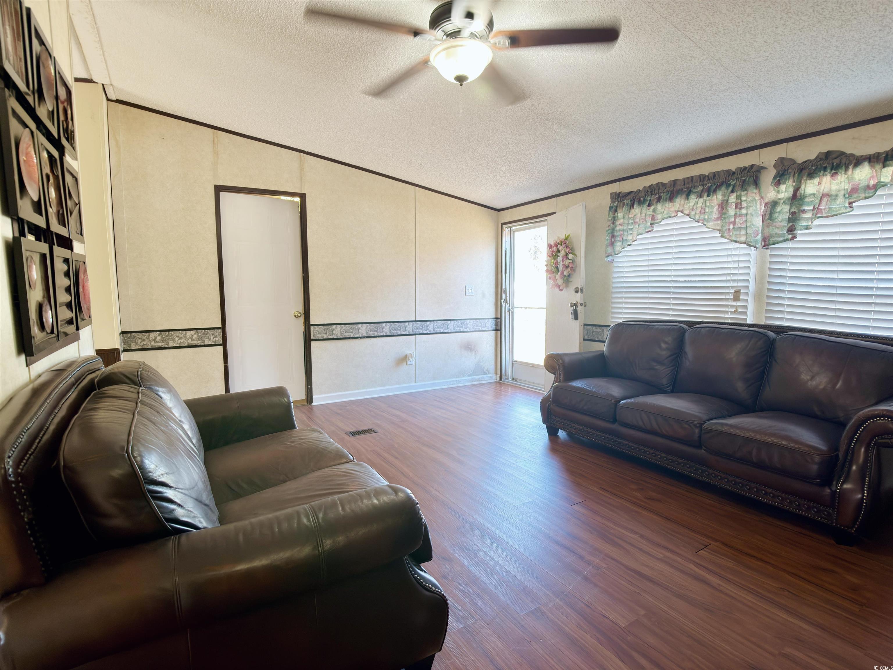 119 Ranchette Circle Myrtle Beach, SC 29588 - Photo 4 of 27 Living room with wood finished floors, a textured ceiling, and a ceiling fan