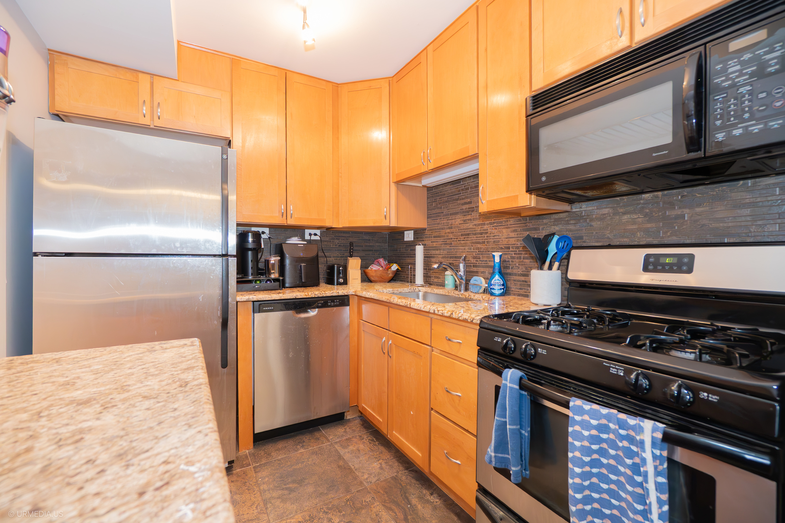 2201 North Cleveland Avenue, Unit 306 Chicago, IL 60614 - Photo 5 of 22 a kitchen with stainless steel appliances granite countertop a stove a refrigerator and a microwave