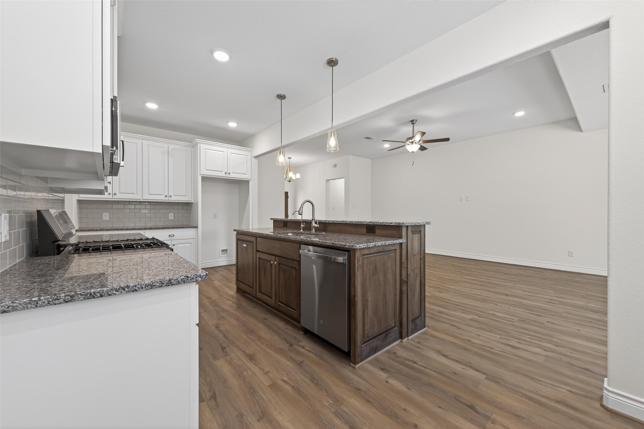 12879 Oak Barrel Road Willis, TX 77378 - Photo 11 of 37 a kitchen with stainless steel appliances granite countertop a sink a stove and a wooden floors