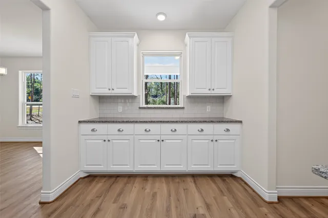 a kitchen with granite countertop white cabinets and white appliances