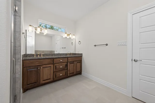 a spacious bathroom with a granite countertop sink and a mirror