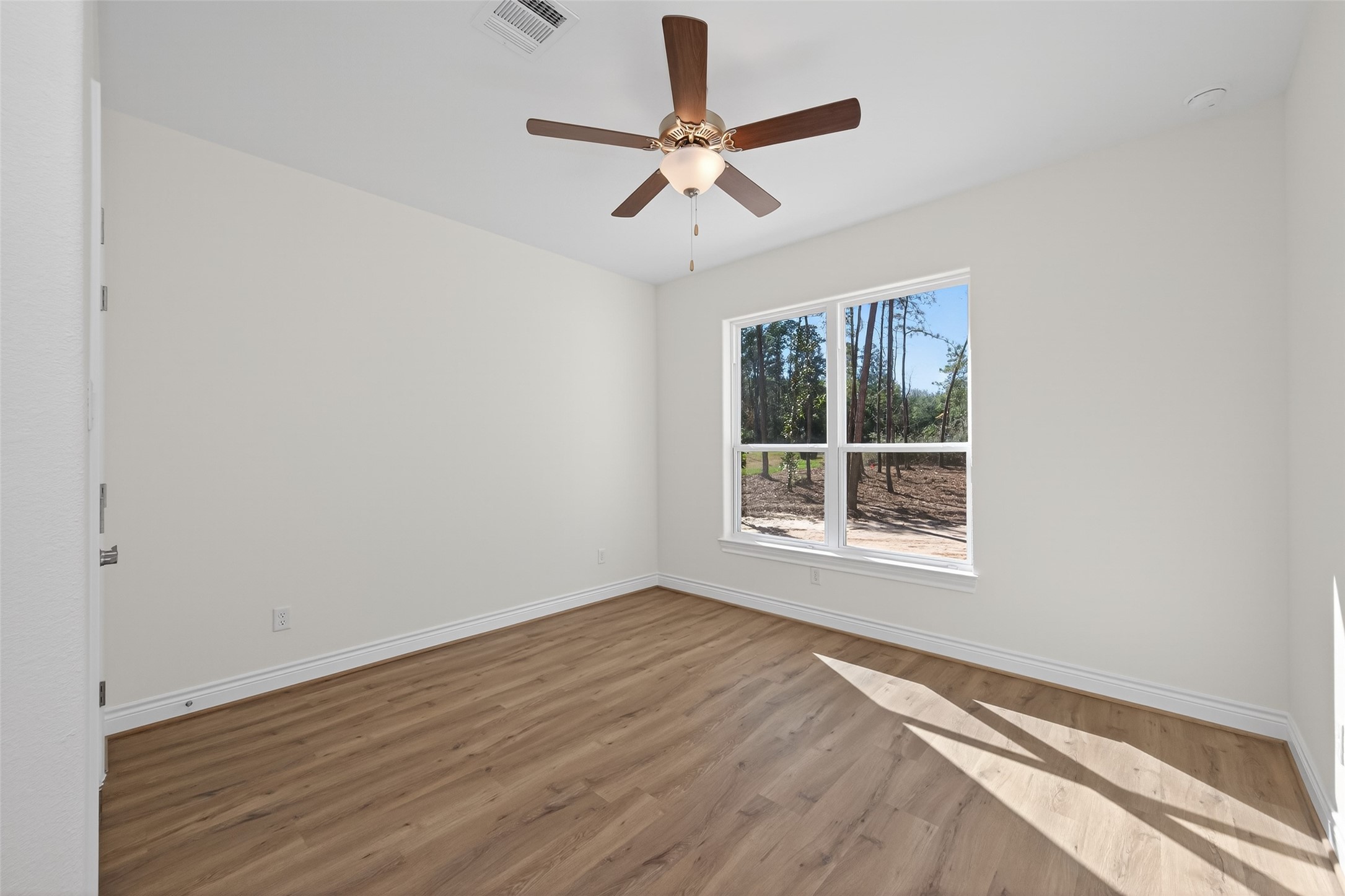 12879 Oak Barrel Road Willis, TX 77378 - Photo 26 of 37 wooden floor in an empty room with a window