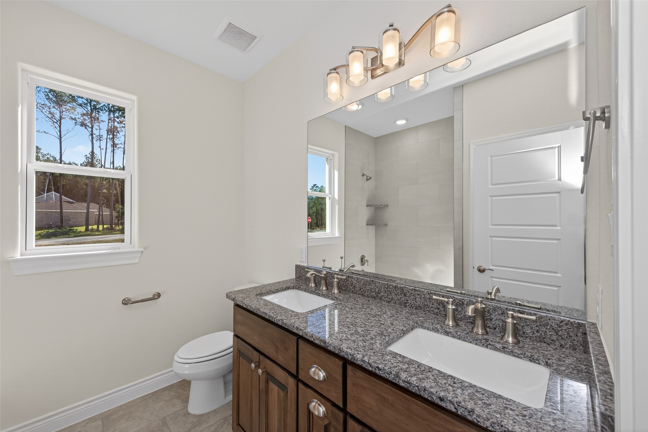 12879 Oak Barrel Road Willis, TX 77378 - Photo 27 of 37 a bathroom with a granite countertop double vanity sink a toilet and a mirror