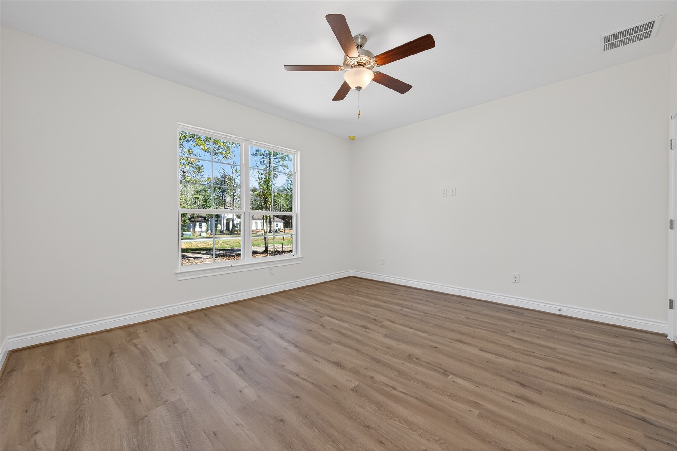 12879 Oak Barrel Road Willis, TX 77378 - Photo 28 of 37 an empty room with wooden floor and windows