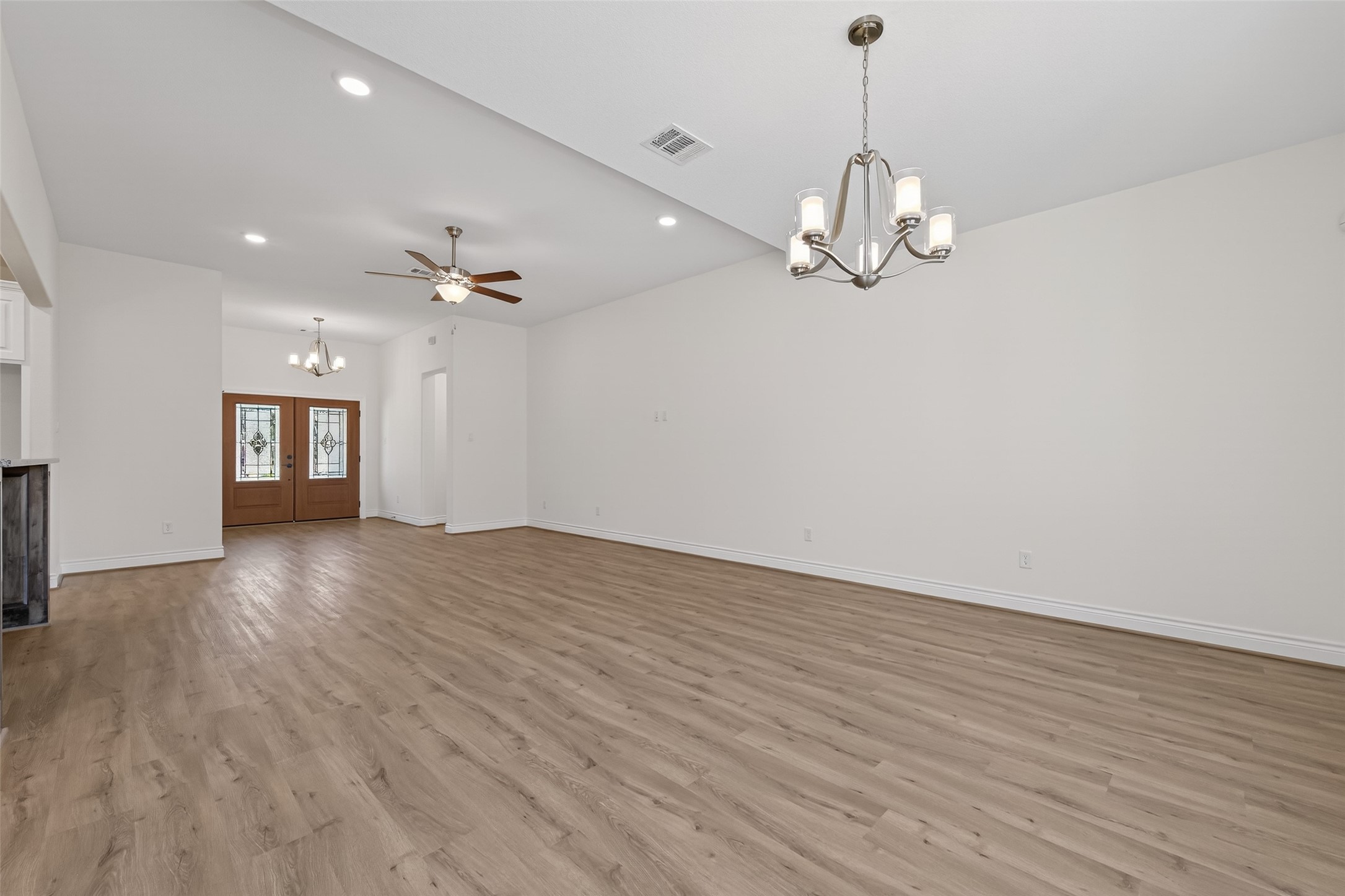 12879 Oak Barrel Road Willis, TX 77378 - Photo 6 of 37 a view of an empty room with wooden floor and a ceiling fan