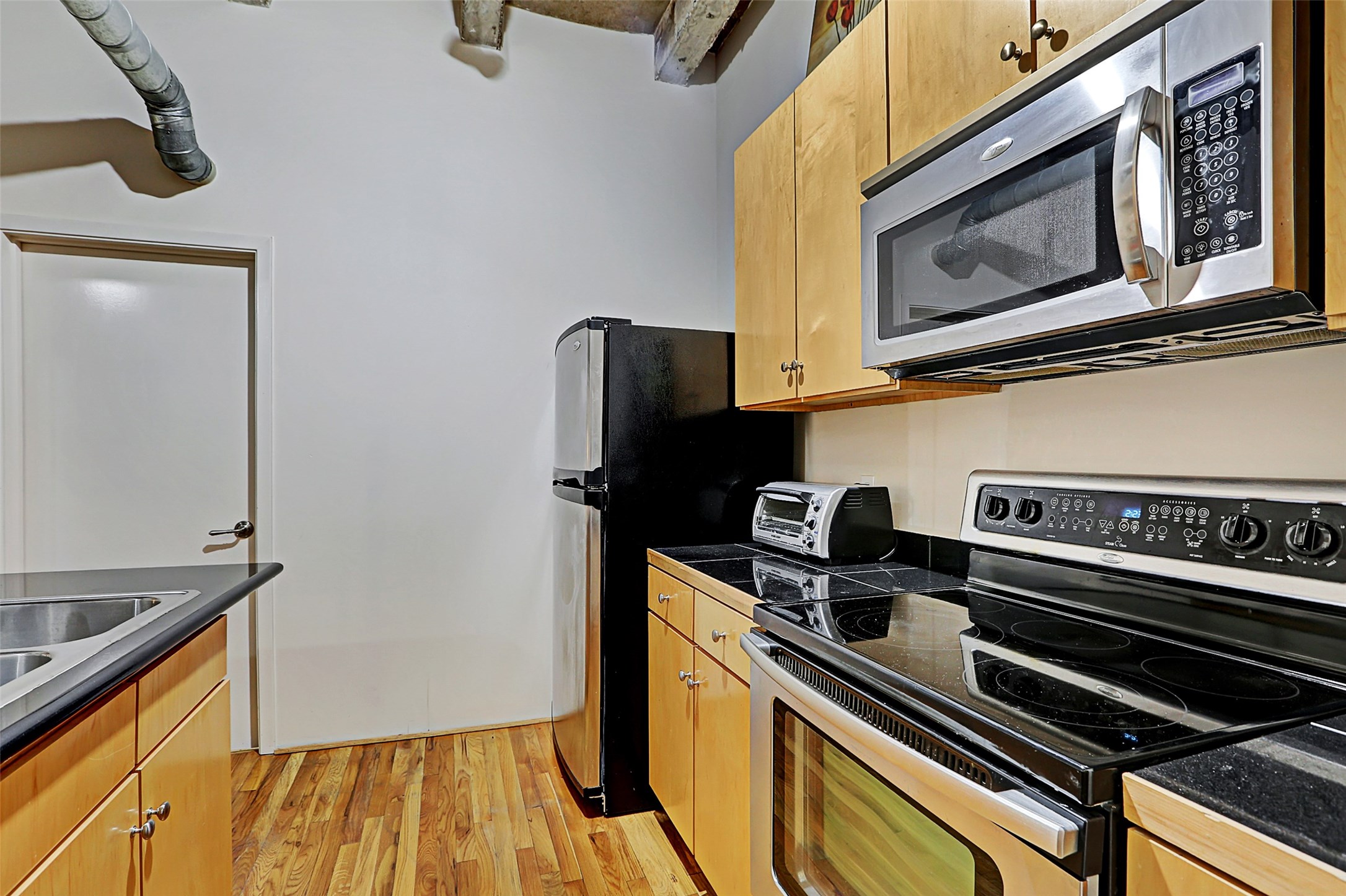 917 Main Street, Unit 503 Houston, TX 77002 - Photo 13 of 31 a kitchen with a stove and a microwave