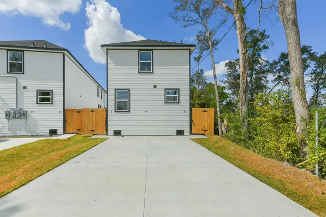 a view of a house with backyard and trees