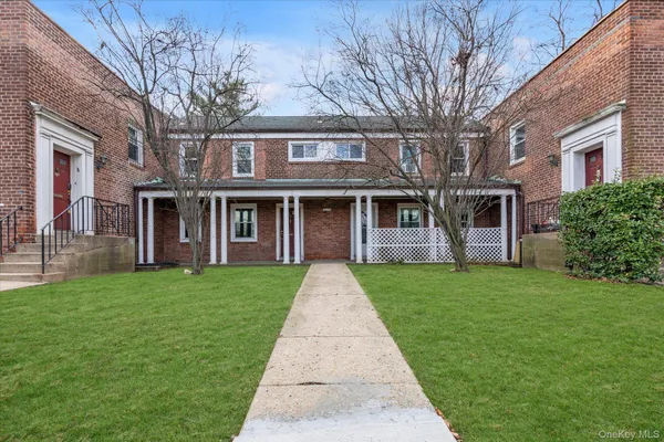 front view of a brick house with a yard