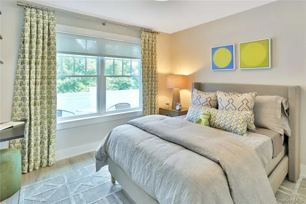 a bedroom with a bed and painting on the wall