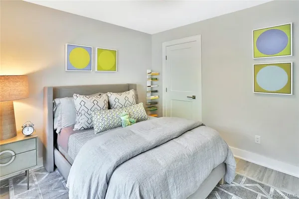 a bedroom with a bed and a painting on the wall