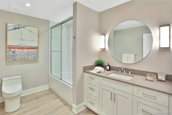 a bathroom with a toilet a sink and mirror