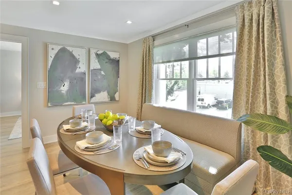 a view of a dining room with furniture a large window and dining table