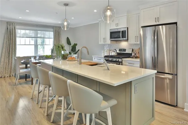 a kitchen with a center island wooden floor and stainless steel appliances