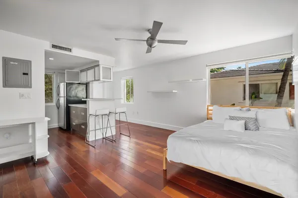 a bedroom with a bed and a large mirror on the dresser