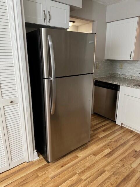 6014 Indrio Road, Unit F2 Fort Pierce, FL 34951 - Photo 5 of 27 a view of a refrigerator in kitchen and an empty room