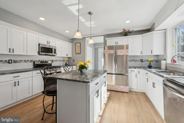 a kitchen with stainless steel appliances granite countertop a stove refrigerator sink and microwave