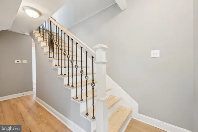 a view of staircase with railing and white walls