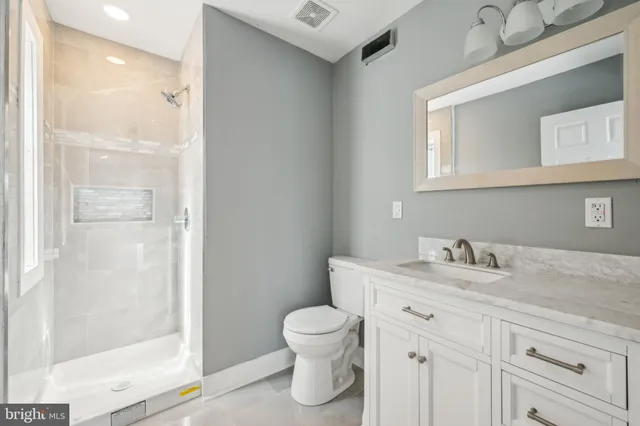 a bathroom with a toilet a sink and a mirror