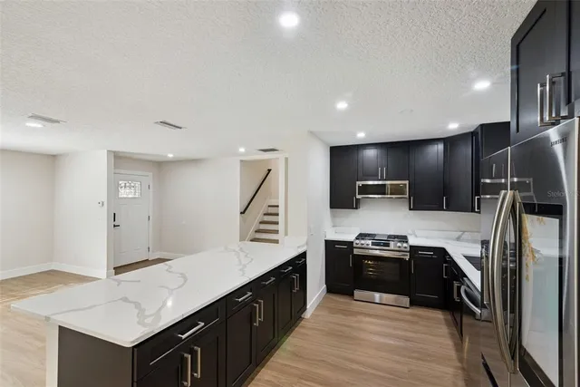 a kitchen with stainless steel appliances a refrigerator and a sink