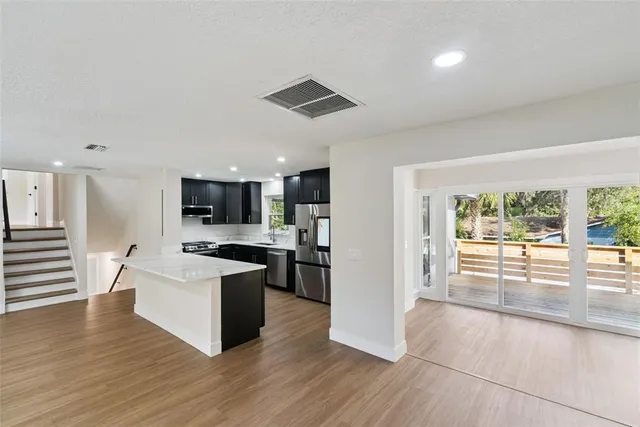 a view of kitchen with refrigerator microwave and wooden floor
