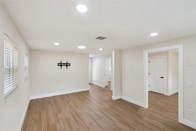 a view of a hallway with wooden floor and closet